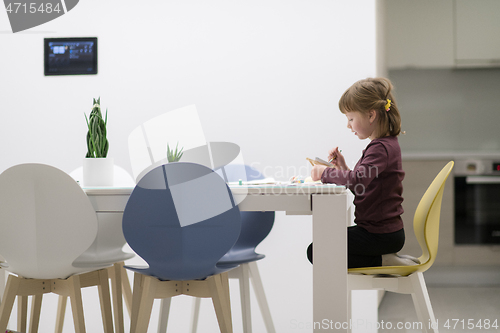 Image of little girl painting on canvas