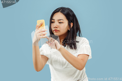Image of Korean young woman\'s half-length portrait on blue background