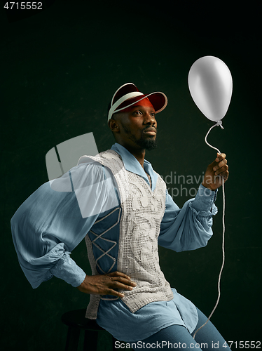 Image of Young man as a medieval knight on dark background