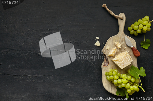 Image of Top view of tasty cheese plate with the fruit on the black stone