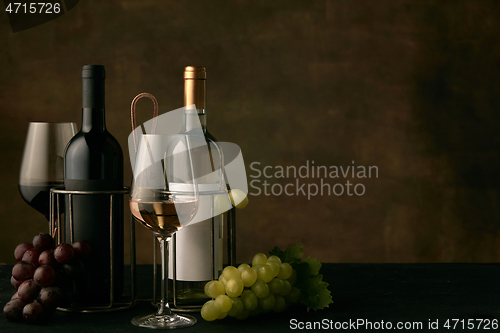 Image of Front view of tasty fruit plate with the wine bottle on dark studio background