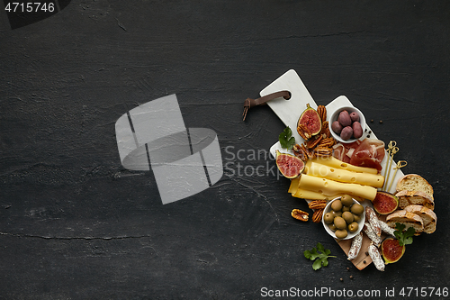 Image of Top view of tasty cheese plate with the fruit on the black stone