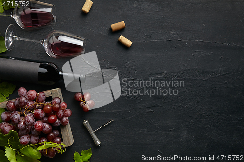 Image of Top view of tasty fruit plate with the wine bottle on the black stone