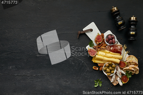 Image of Top view of tasty cheese plate with the fruit on the black stone