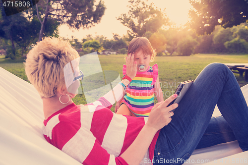 Image of mom and a little daughter relaxing in a hammock