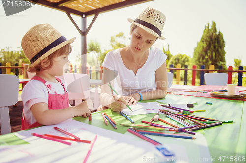 Image of mom and little daughter drawing a colorful pictures