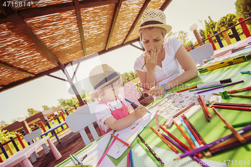 Image of mom and little daughter drawing a colorful pictures