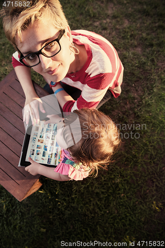 Image of mom and her little daughter using tablet computer