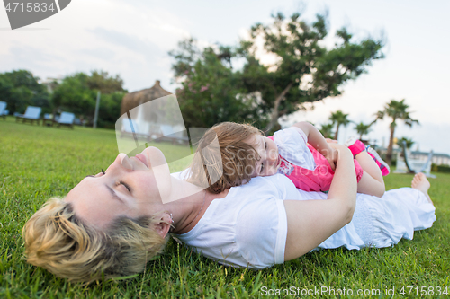 Image of mother and little daughter playing at backyard