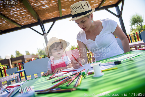 Image of mom and little daughter drawing a colorful pictures