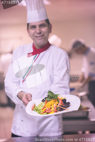 Image of Chef showing a plate of tasty meal