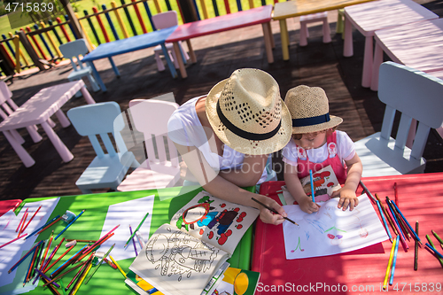 Image of mom and little daughter drawing a colorful pictures