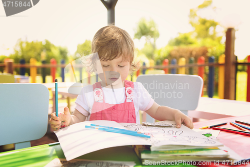 Image of little girl drawing a colorful pictures