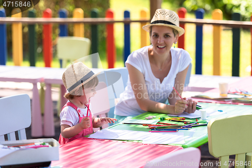 Image of mom and little daughter drawing a colorful pictures