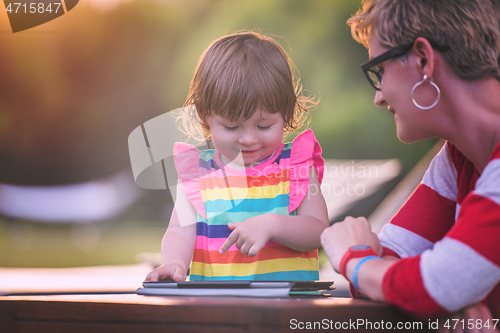 Image of mom and her little daughter using tablet computer