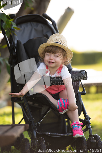 Image of baby girl sitting in the baby stroller