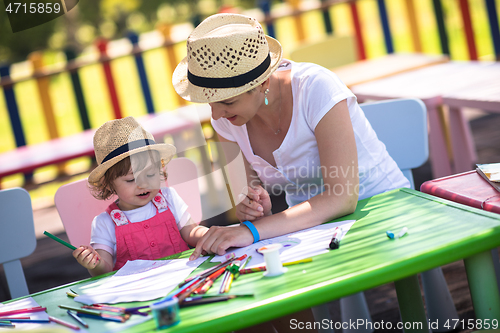 Image of mom and little daughter drawing a colorful pictures