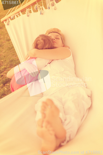 Image of mother and a little daughter relaxing in a hammock