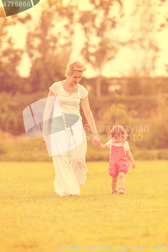 Image of mother and little daughter playing at backyard