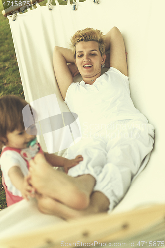 Image of mother and a little daughter relaxing in a hammock