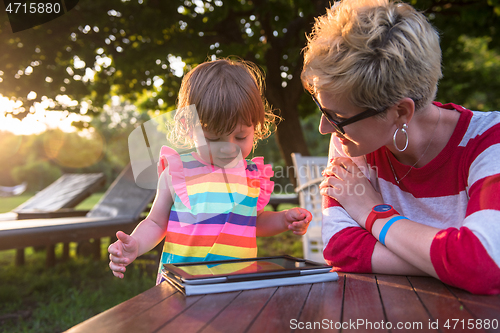 Image of mom and her little daughter using tablet computer