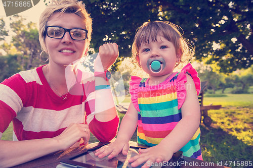 Image of mom and her little daughter using tablet computer