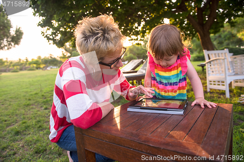 Image of mom and her little daughter using tablet computer