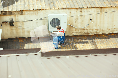 Image of HVAC technician working on a capacitor part for condensing unit