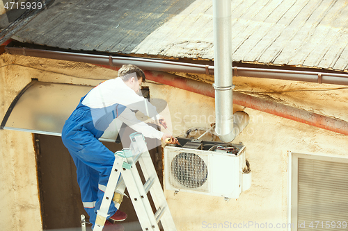 Image of HVAC technician working on a capacitor part for condensing unit