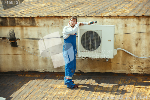 Image of HVAC technician working on a capacitor part for condensing unit