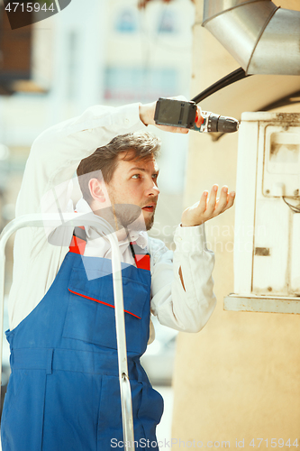 Image of HVAC technician working on a capacitor part for condensing unit