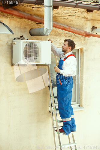 Image of HVAC technician working on a capacitor part for condensing unit