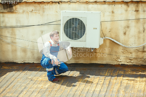 Image of HVAC technician working on a capacitor part for condensing unit