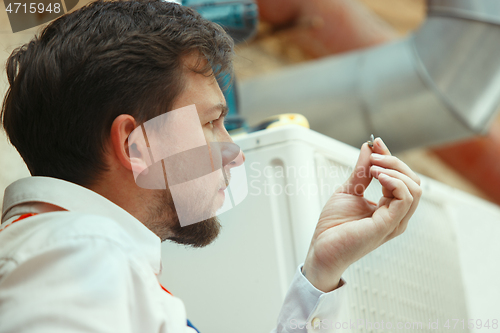 Image of HVAC technician working on a capacitor part for condensing unit