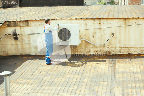 Image of HVAC technician working on a capacitor part for condensing unit