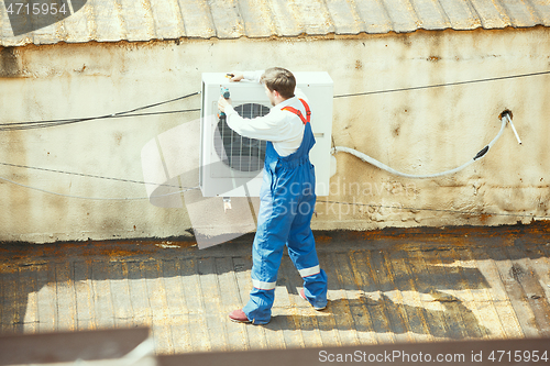 Image of HVAC technician working on a capacitor part for condensing unit