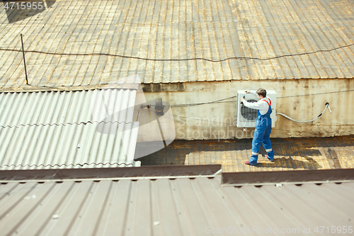 Image of HVAC technician working on a capacitor part for condensing unit