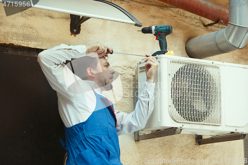 Image of HVAC technician working on a capacitor part for condensing unit