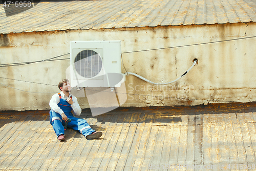 Image of HVAC technician working on a capacitor part for condensing unit