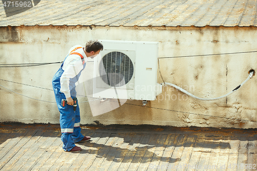 Image of HVAC technician working on a capacitor part for condensing unit