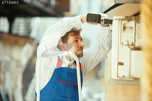 Image of HVAC technician working on a capacitor part for condensing unit