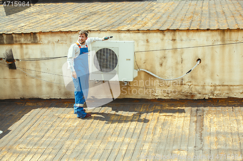 Image of HVAC technician working on a capacitor part for condensing unit