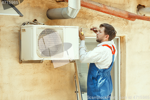 Image of HVAC technician working on a capacitor part for condensing unit