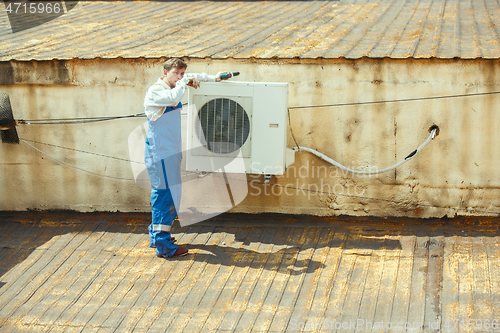 Image of HVAC technician working on a capacitor part for condensing unit