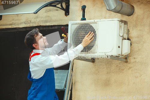 Image of HVAC technician working on a capacitor part for condensing unit