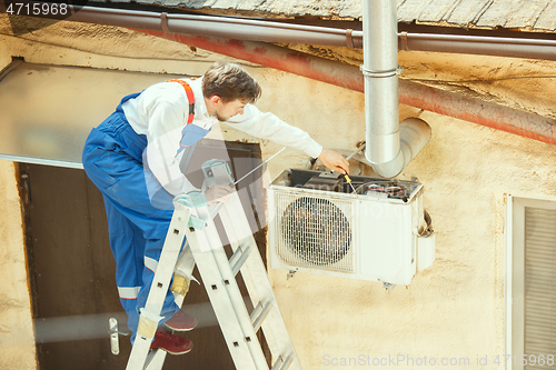 Image of HVAC technician working on a capacitor part for condensing unit