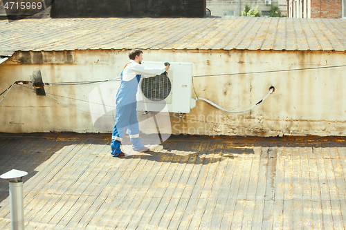 Image of HVAC technician working on a capacitor part for condensing unit