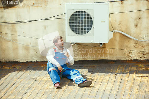 Image of HVAC technician working on a capacitor part for condensing unit