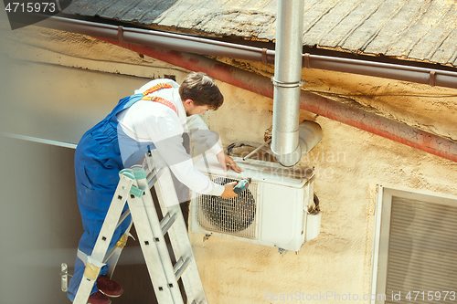 Image of HVAC technician working on a capacitor part for condensing unit