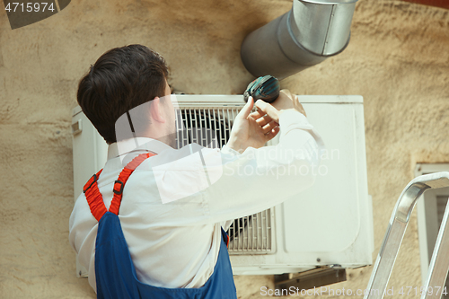 Image of HVAC technician working on a capacitor part for condensing unit